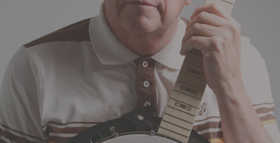 an older gentleman in a button up shirt holding a banjo
