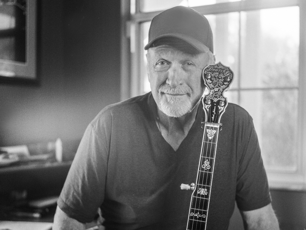 mark johnson with deering clawgrass banjo and baseball cap in black and white