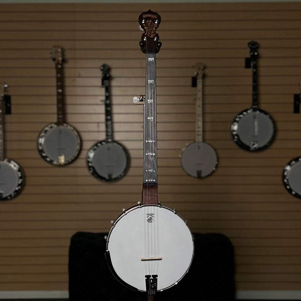 Collection of banjos displayed on a wall in a room with framed pictures.