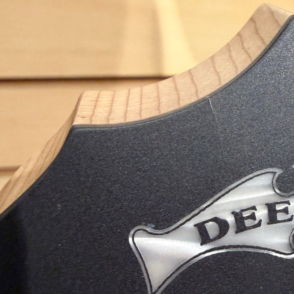 Close-up of a Deering logo on a wooden background