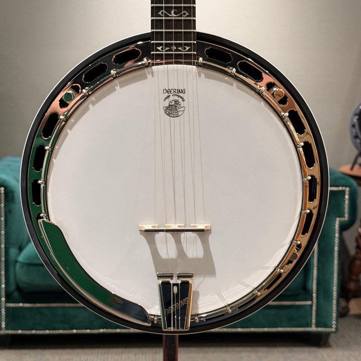 Close up of stringed instrument in front of a gray wall and green couch
