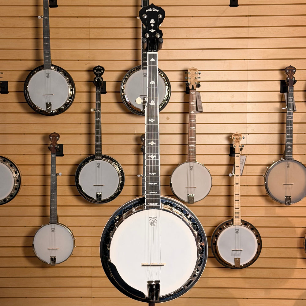 Collection of banjos displayed on a wooden wall.