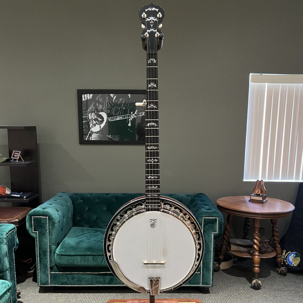 Banjo on a stand in a room with green velvet couch and table