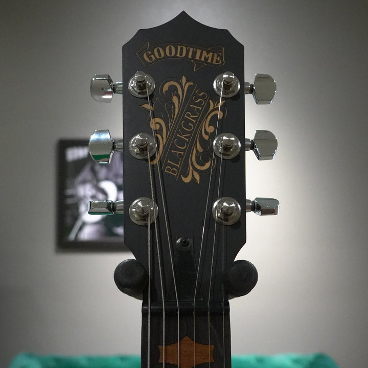Guitar headstock with 'blackgrass: branding against a blurred background
