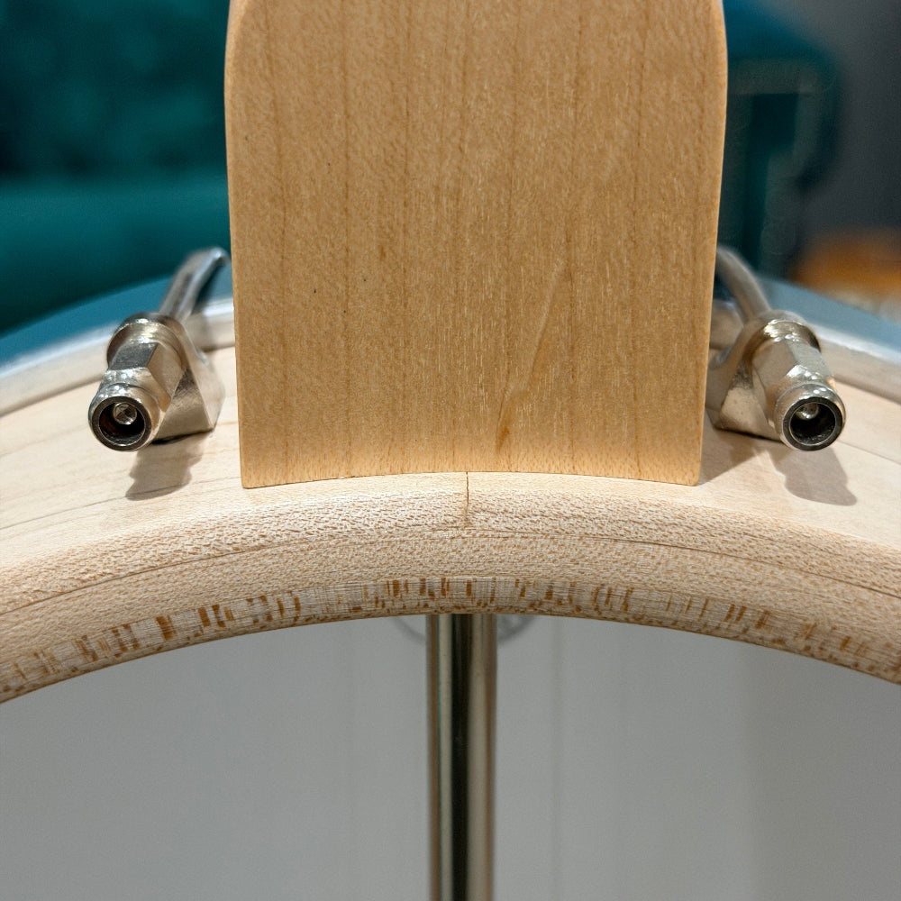 Close-up of a banjo rim with metal attachments on a blurred background