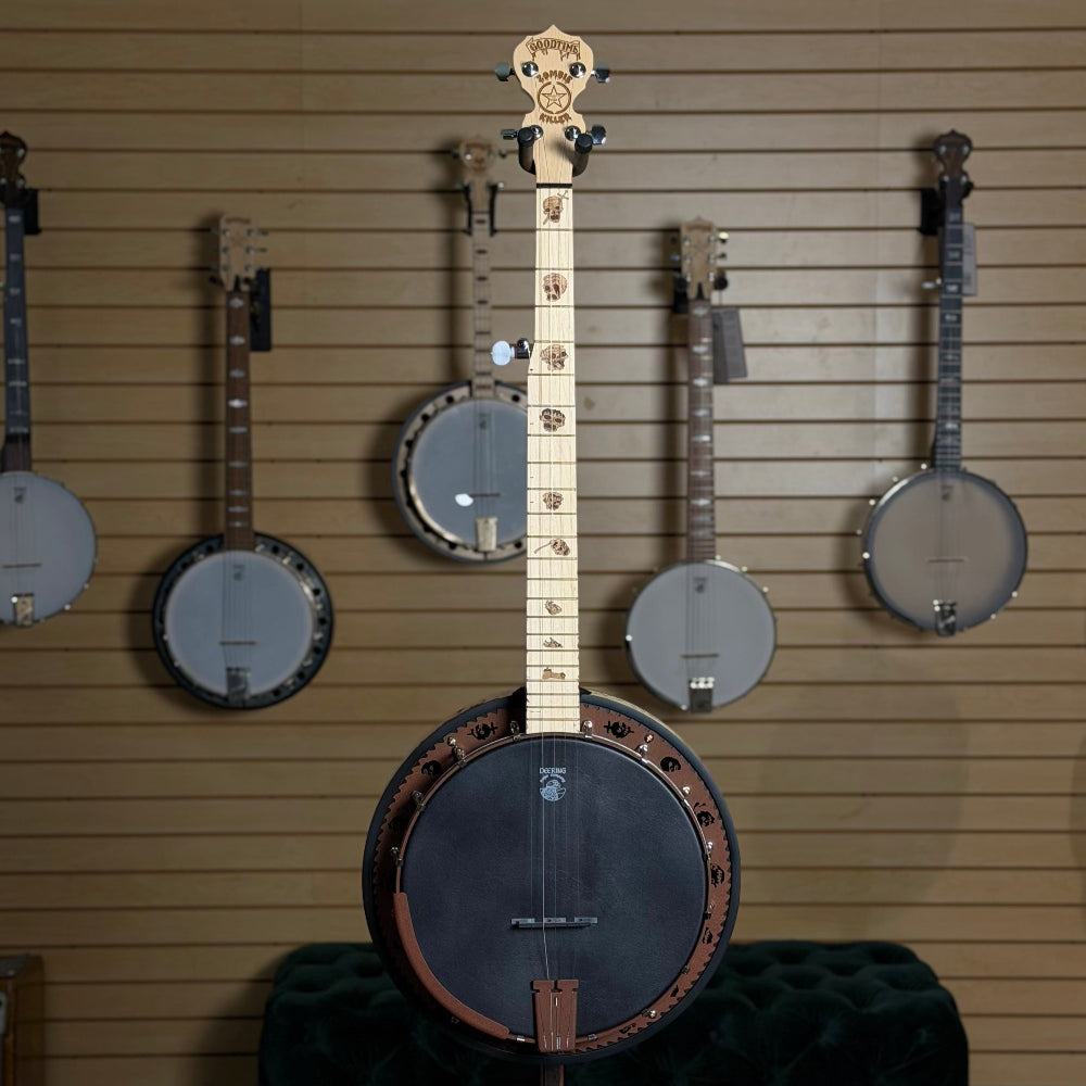 banjo with black head and maple fingerboard Zombie theme in front of wall of banjos