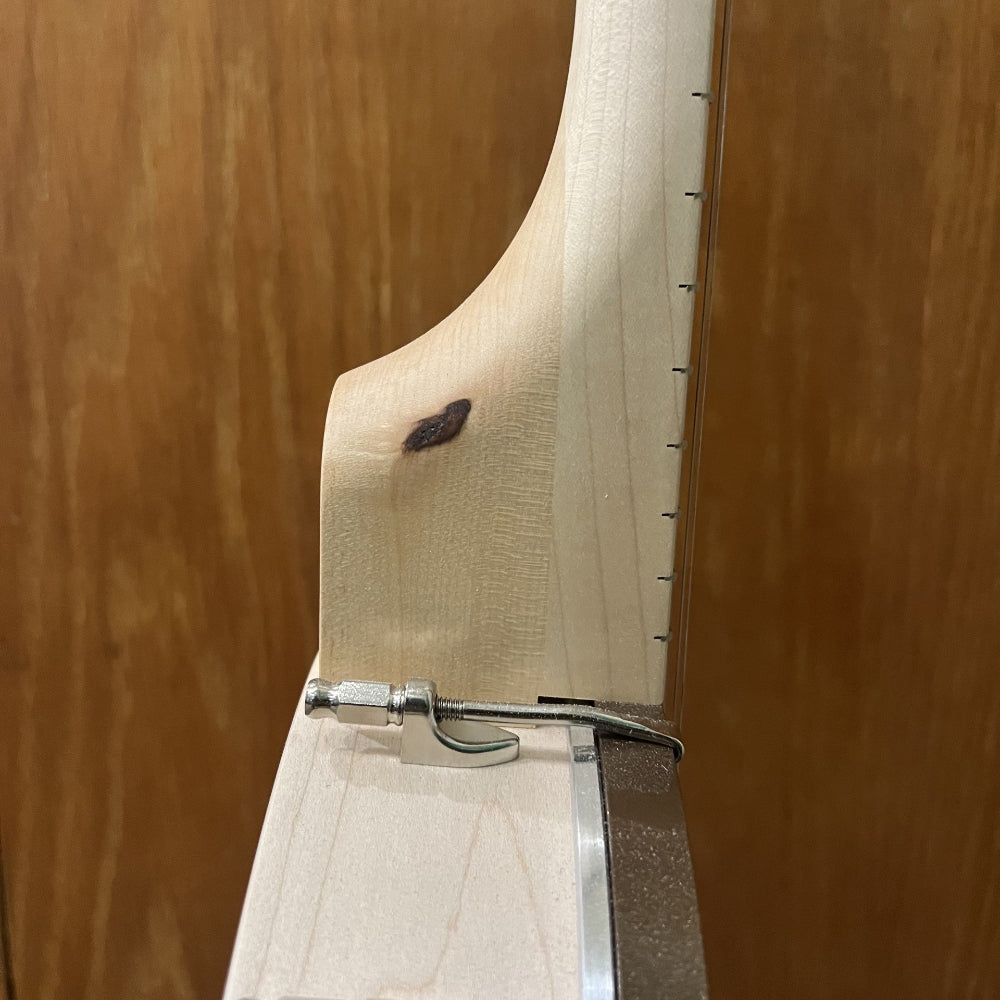 close up of banjo neck with dark knot in the center. 
