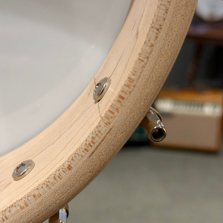 Close-up of a wooden rim product with metal fasteners on a blurred background