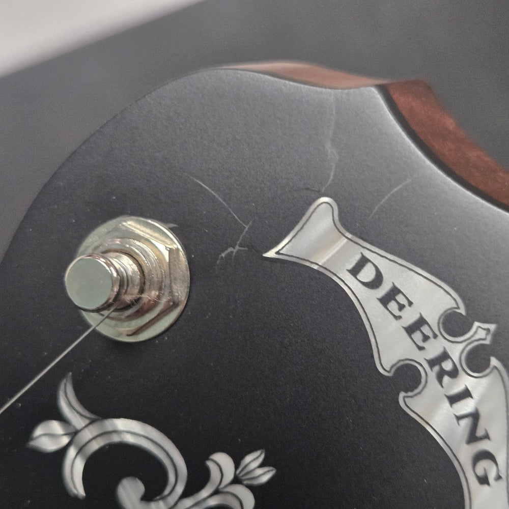 Close-up of a guitar headstock with 'Deering' branding.