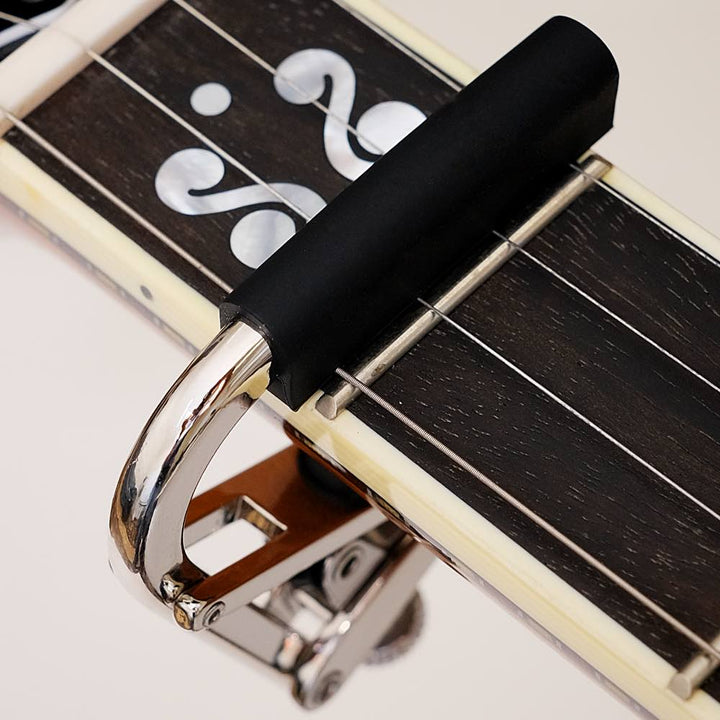 Shubb Banjo Capo, on banjo, closeup, white background